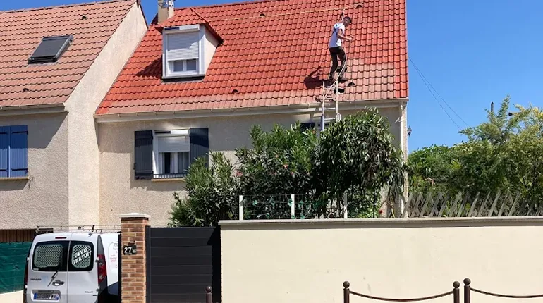 homme entrain de faire un démoussage et nettoyage sur une toiture
